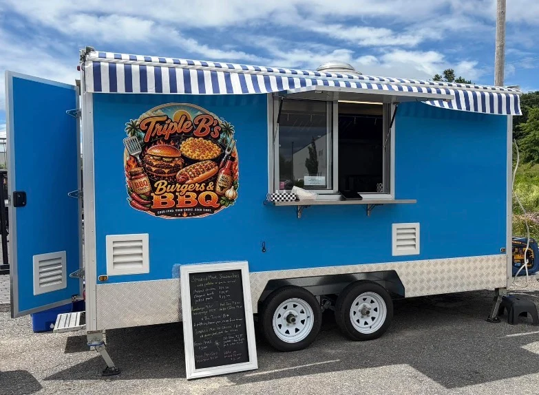 Triple B's Burgers & BBQ trailer with its navy and white striped awning